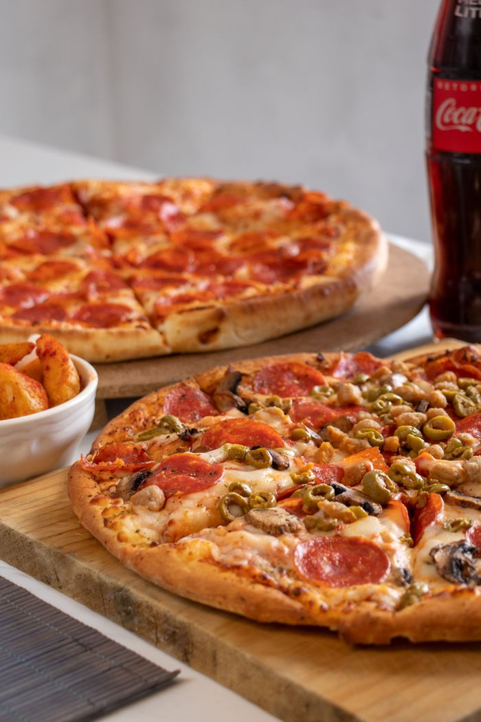 services-01 Close-up of pepperoni and veggie pizzas with soda, perfect for a casual dining experience.