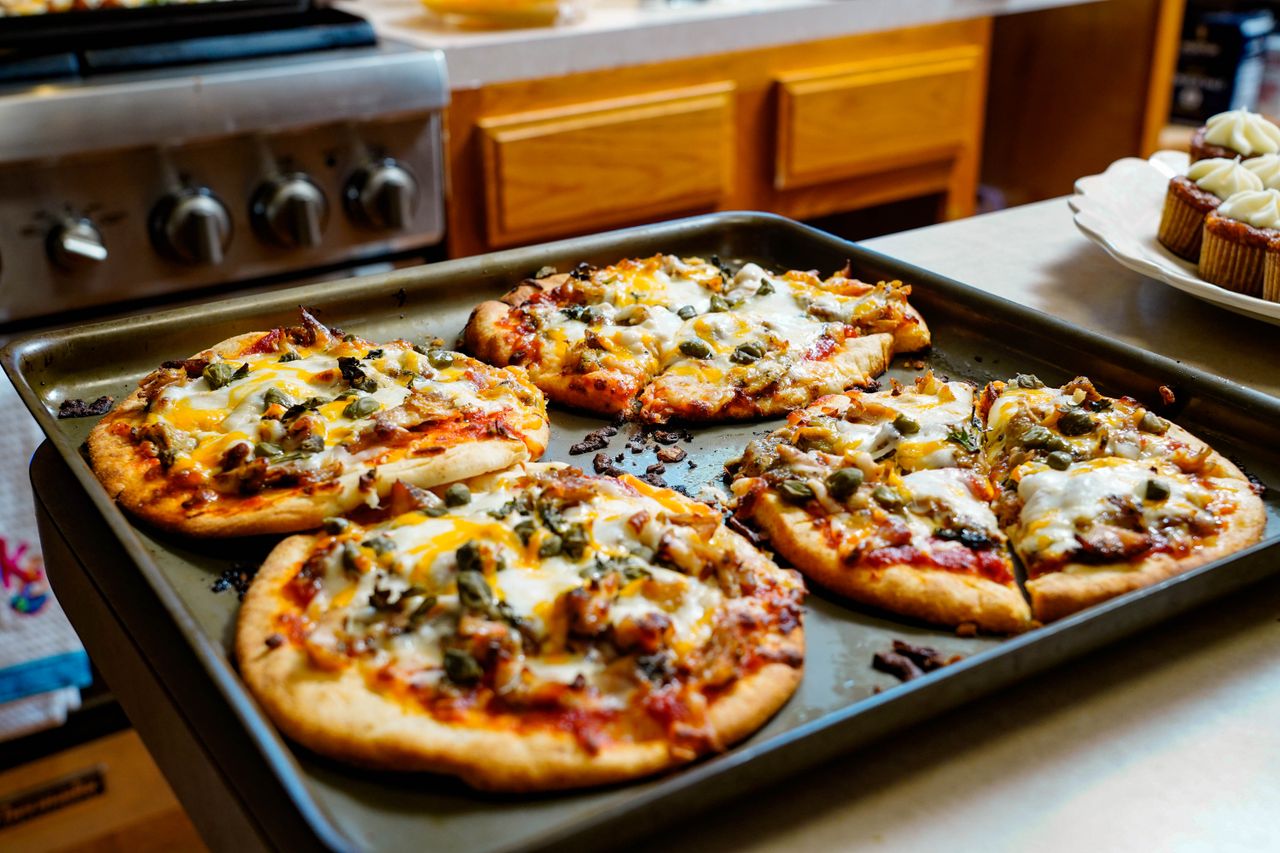 services-03 Freshly baked pizzas with melted cheese on a kitchen counter, ideal for foodies.